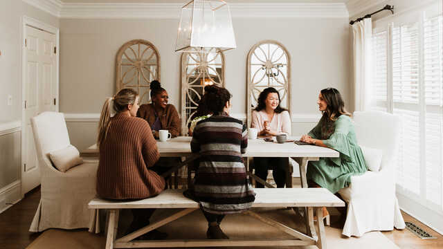 group of women having a discussion over a kitchen table