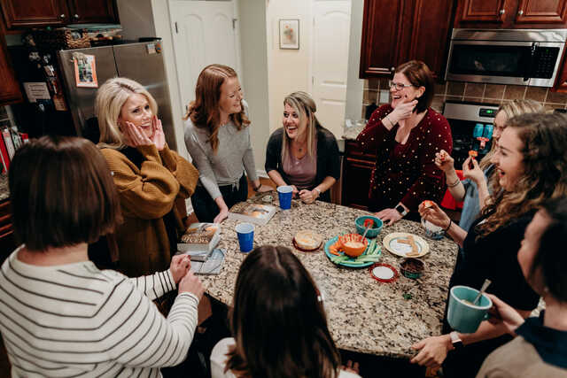 group of women laughing in a kitchen
