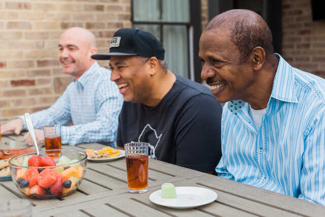 group of men having a lighthearted conversation outside
