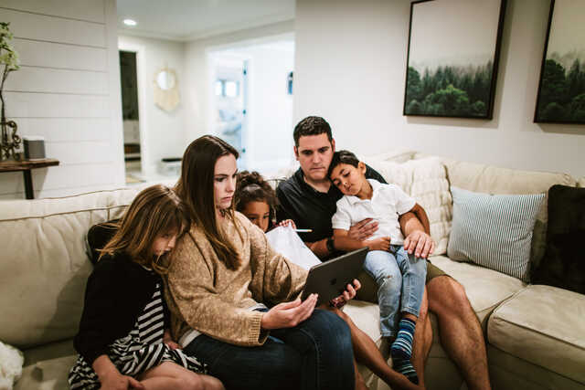family watching church on an ipad at home on the couch