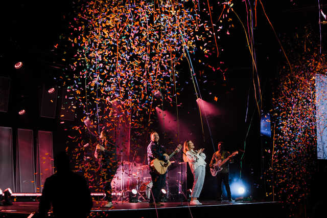 band on stage at hamilton mill church with confetti falling