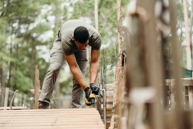 young man constructing a wooden pathway during a service project